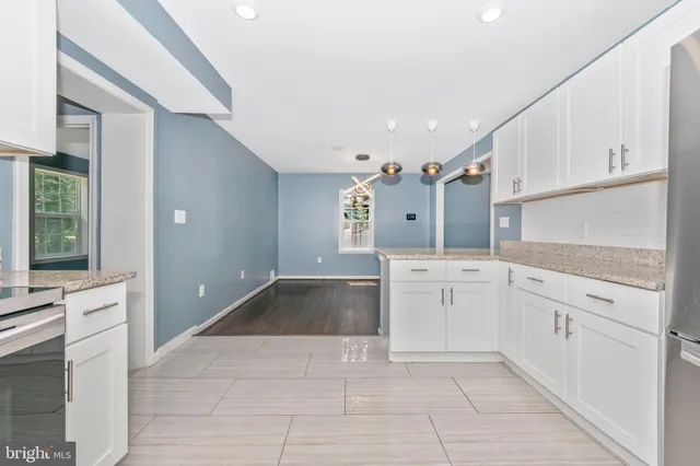 a large white kitchen with cabinets