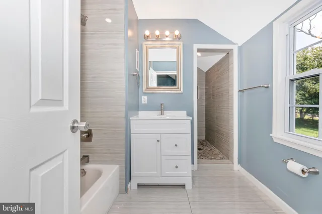 a bathroom with a sink a tub and a mirror