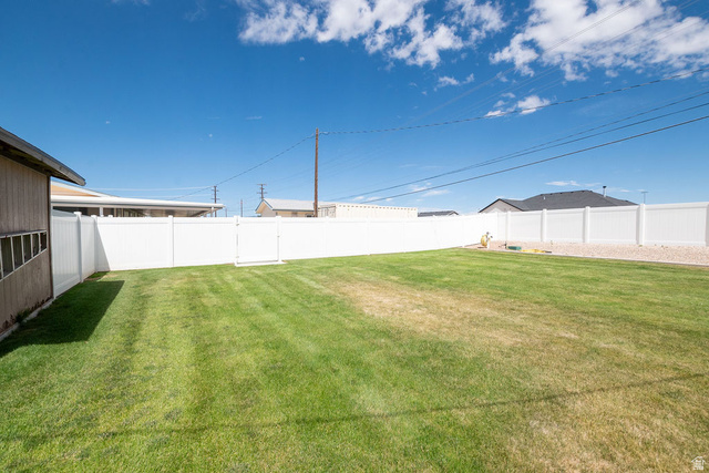 855 East 300 N Street Beaver, UT 84713 - Photo 10 of 44 Spacious backyard featuring a manicured lawn, full privacy fencing, and a gravel border