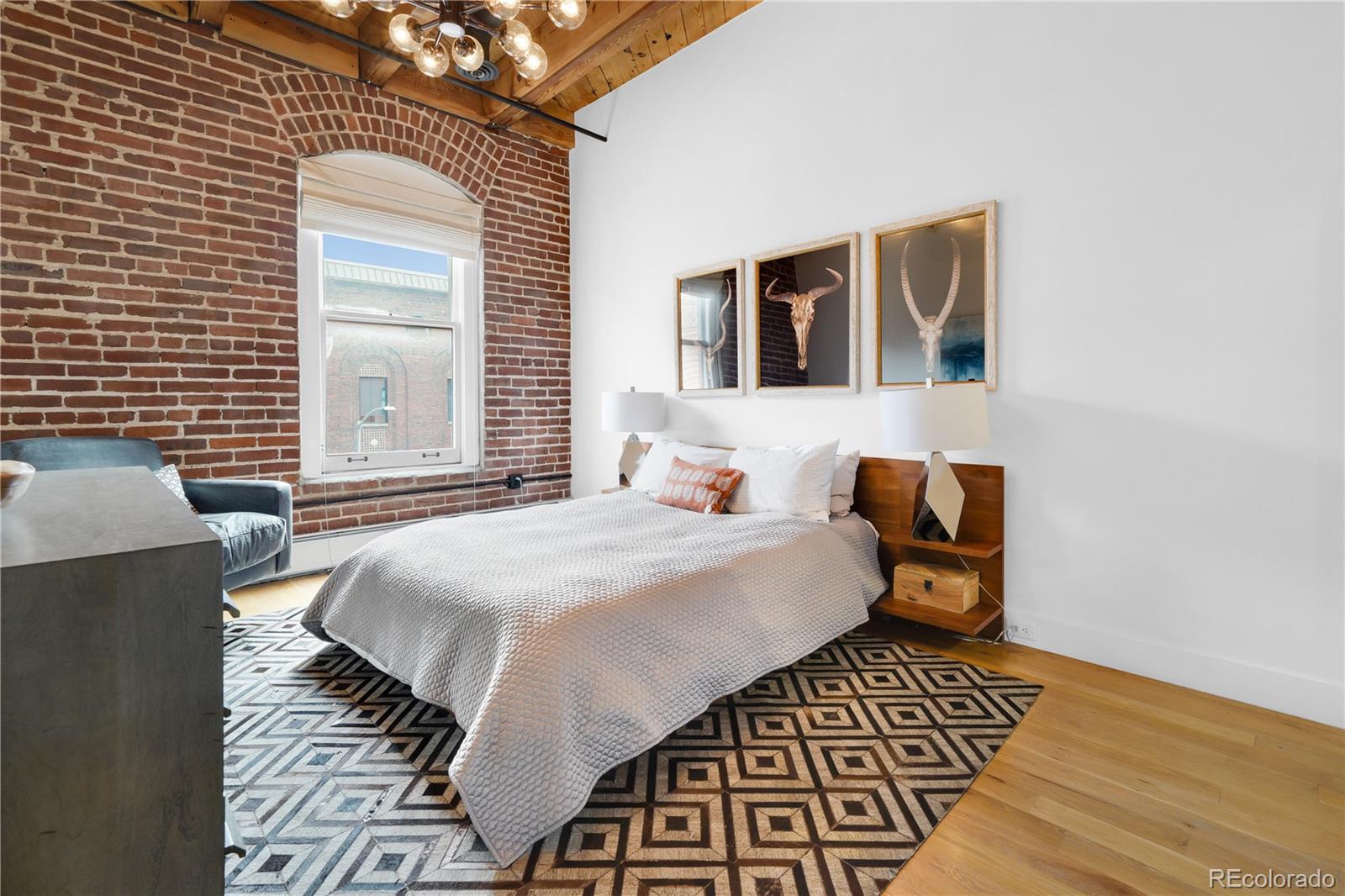 1792 Wynkoop Street, Unit 307 Denver, CO 80202 - Photo 12 of 26 a bedroom with a bed and wooden floor