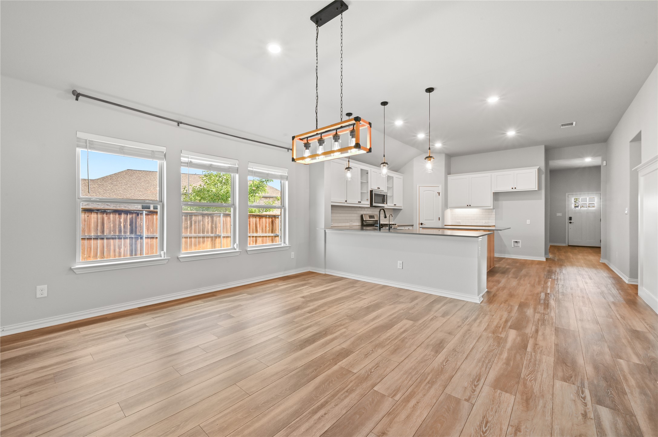 426 Cold Riv Run Kyle, TX 78640 - Photo 13 of 34 An open concept living and dining area seamlessly connects to a modern kitchen, bathed in natural light.
