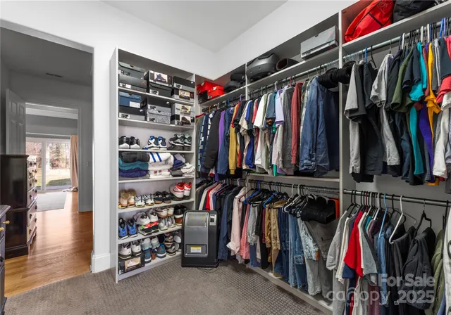 a view of walk in closet with clothes and shoes