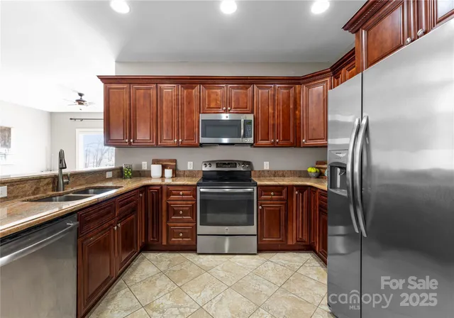 a kitchen with stainless steel appliances granite countertop a stove top oven a sink and dishwasher