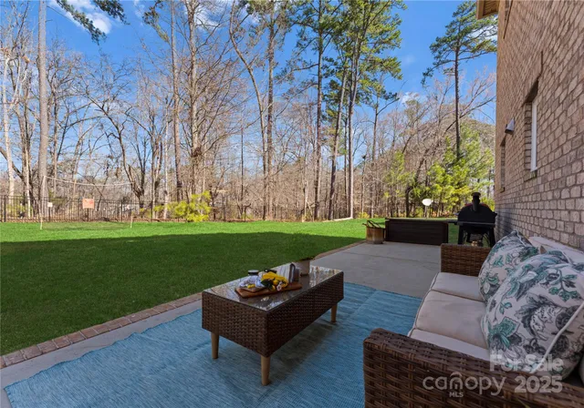 a view of a couches in a park with large trees