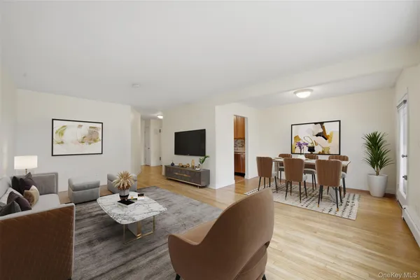 a living room with furniture a wooden floor and a flat screen tv