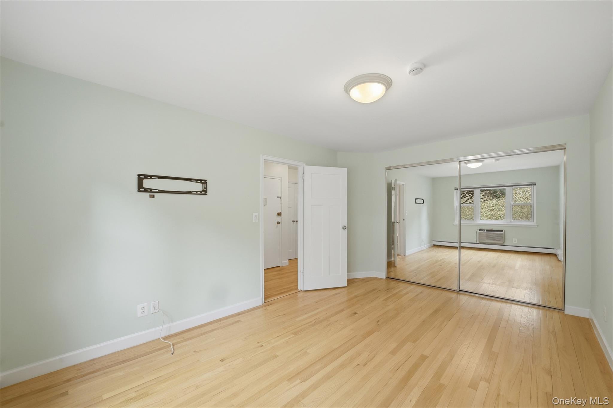 667 Pelham Road, Unit B10 New Rochelle, NY 10805 - Photo 7 of 16 an empty room with wooden floor and sliding door