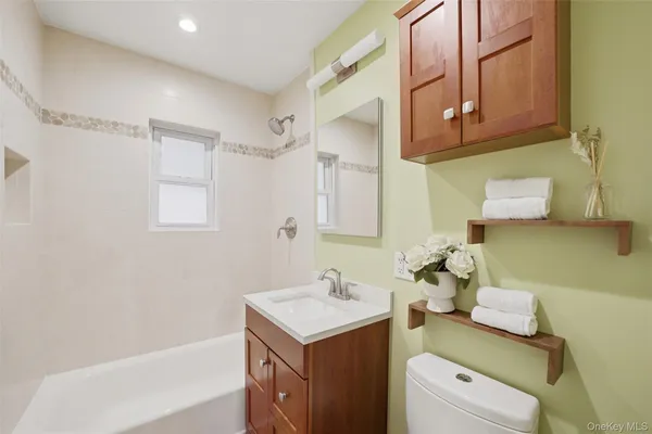 a bathroom with a sink toilet vanity and tub