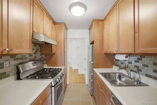 a kitchen with stainless steel appliances a sink a stove and a refrigerator