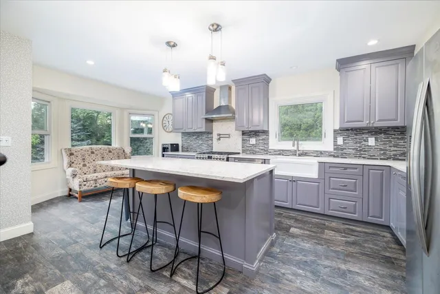 a kitchen with stainless steel appliances granite countertop a sink a stove a refrigerator and cabinets