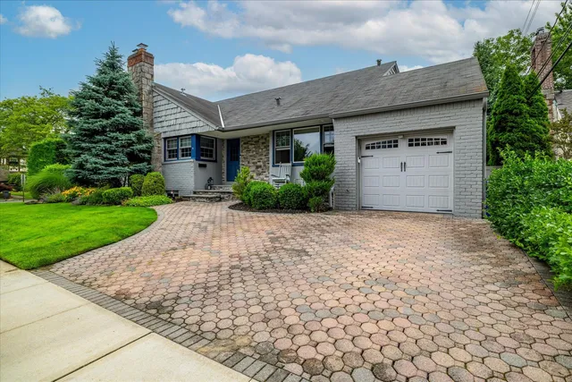 a front view of a house with a garden and plants