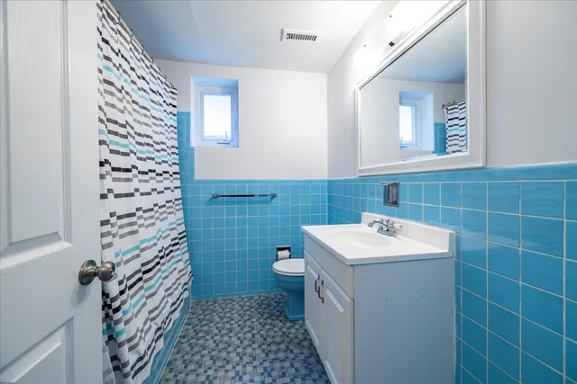 a bathroom with a sink a toilet and a mirror