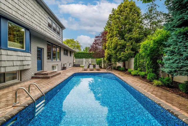 a view of a house with swimming pool and sitting area