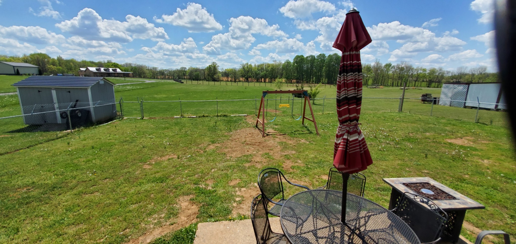 140 T G T Road Portland, TN 37148 - Photo 13 of 13 a view of a backyard with table and chairs a fire pit and two lawn chairs