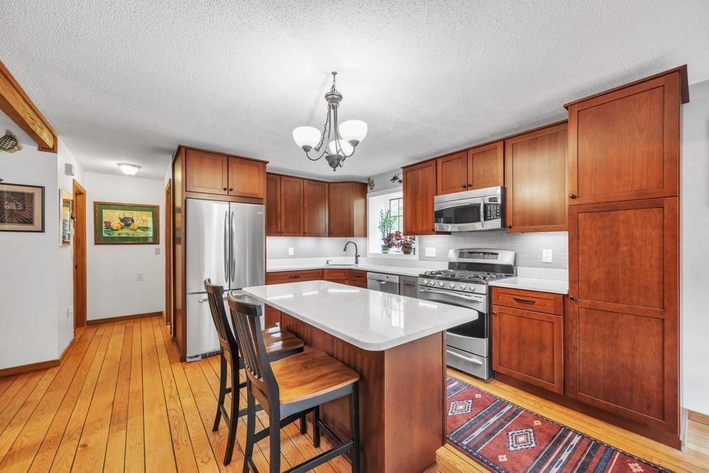1 St Germain Road Hampden, MA 01036 - Photo 18 of 42 a kitchen with stainless steel appliances granite countertop a refrigerator a stove top oven a sink dishwasher and wooden cabinets with wooden floor
