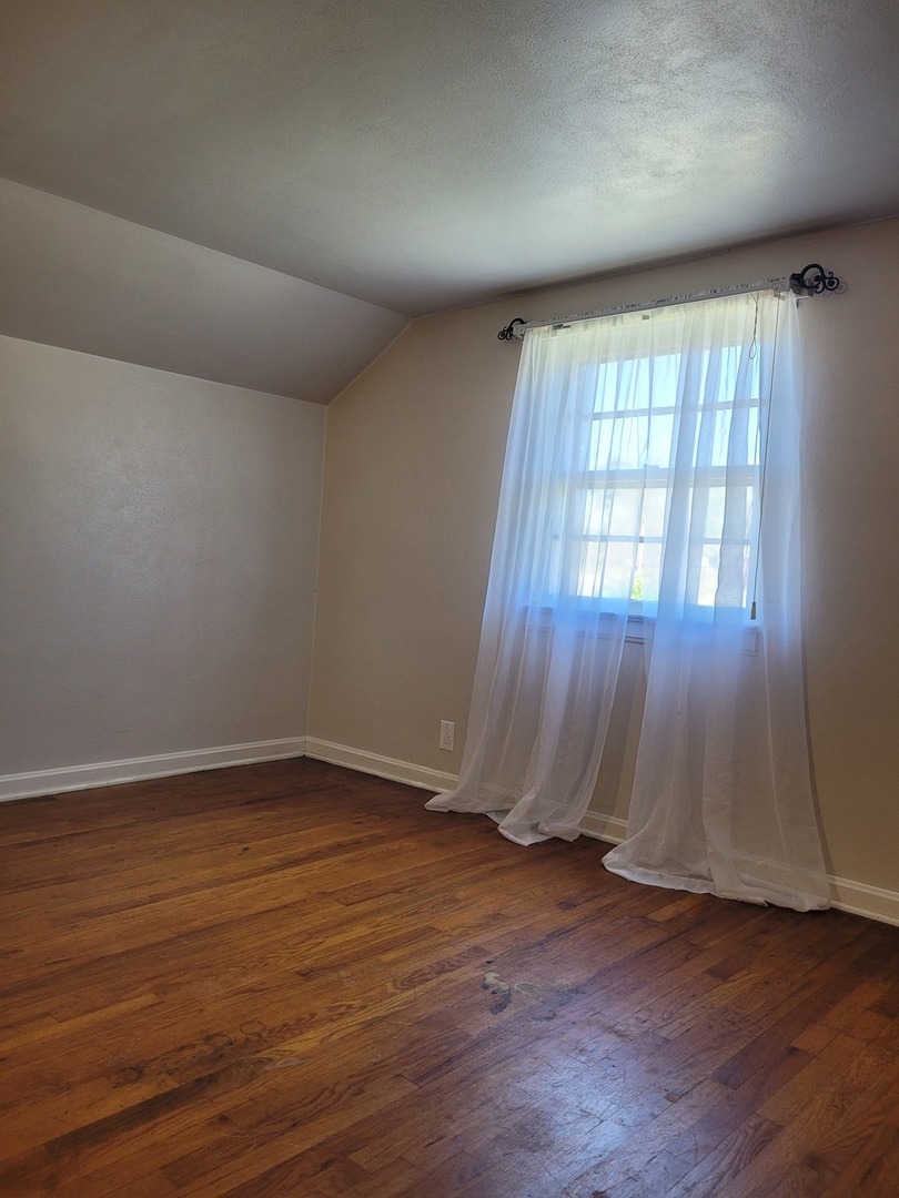 507 North 12th Street Mount Vernon, IL 62864 - Photo 21 of 23 an empty room with wooden floor and windows with curtains