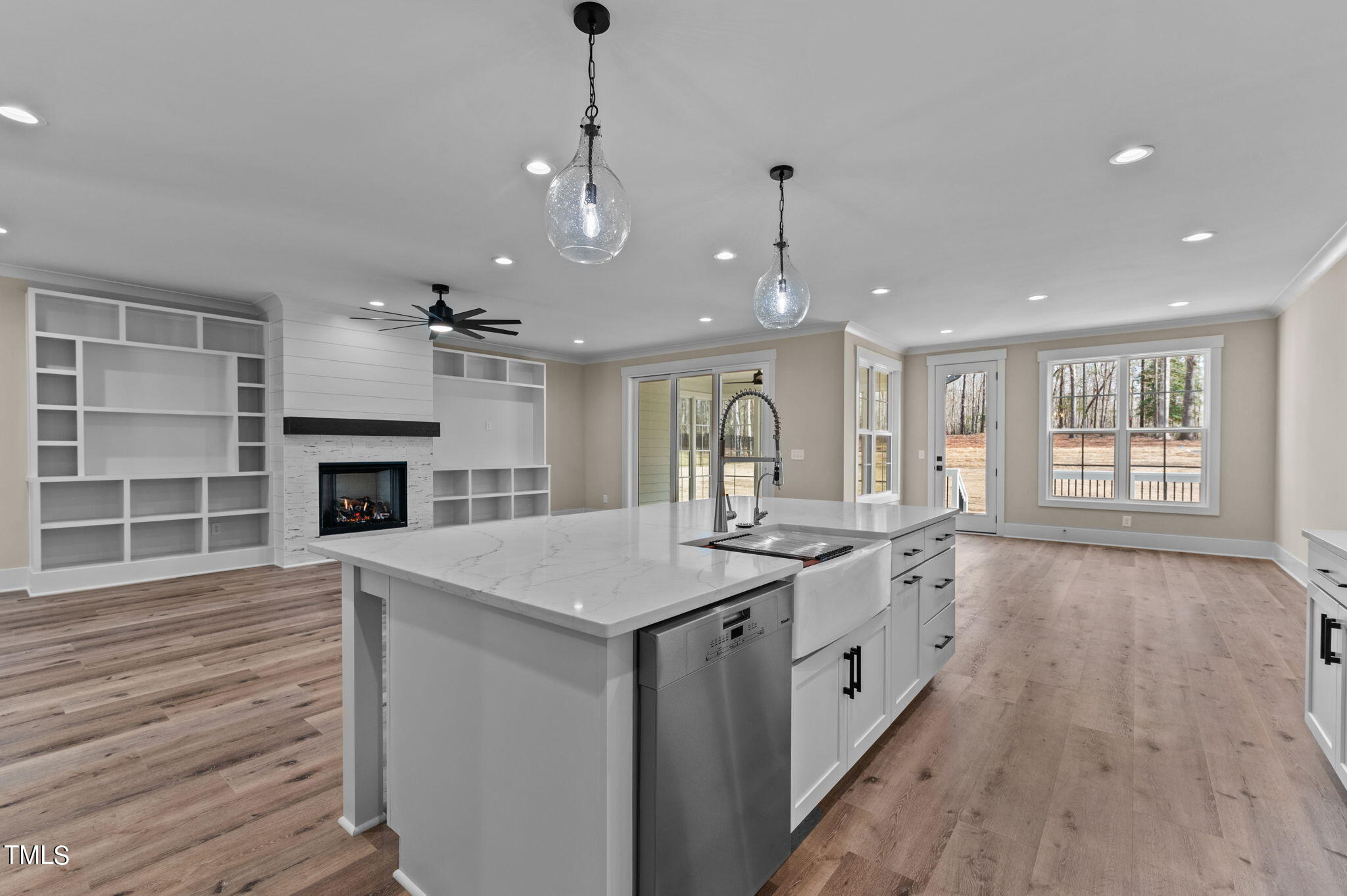 3816 Old Milburnie Road Raleigh, NC 27616 - Photo 30 of 58 a large kitchen with a stove a sink dishwasher and a fireplace with wooden floor
