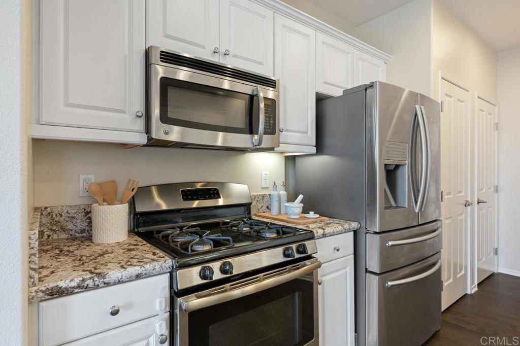 6610 Canopy Ridge Lane, Unit 37 San Diego, CA 92121 - Photo 26 of 65 a kitchen with stainless steel appliances granite countertop a stove microwave and refrigerator