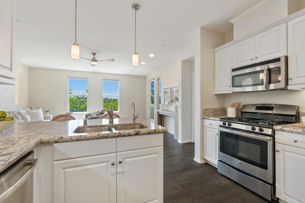 6610 Canopy Ridge Lane, Unit 37 San Diego, CA 92121 - Photo 29 of 65 a kitchen with stainless steel appliances granite countertop a stove a sink and a microwave