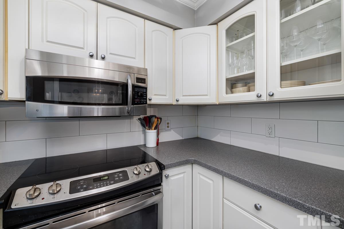 1336 Dylan Heath Court Raleigh, NC 27608 - Photo 15 of 25 a kitchen with granite countertop white cabinets and appliances