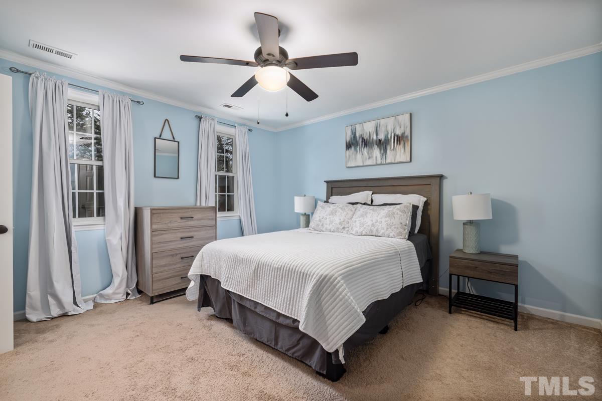 1336 Dylan Heath Court Raleigh, NC 27608 - Photo 17 of 25 a spacious bedroom with a bed and a chandelier
