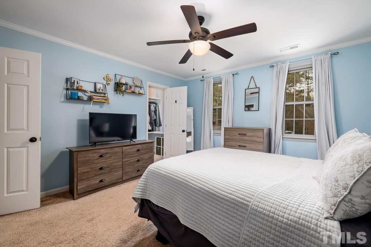 1336 Dylan Heath Court Raleigh, NC 27608 - Photo 18 of 25 a bedroom with a bed a flat screen tv and a window