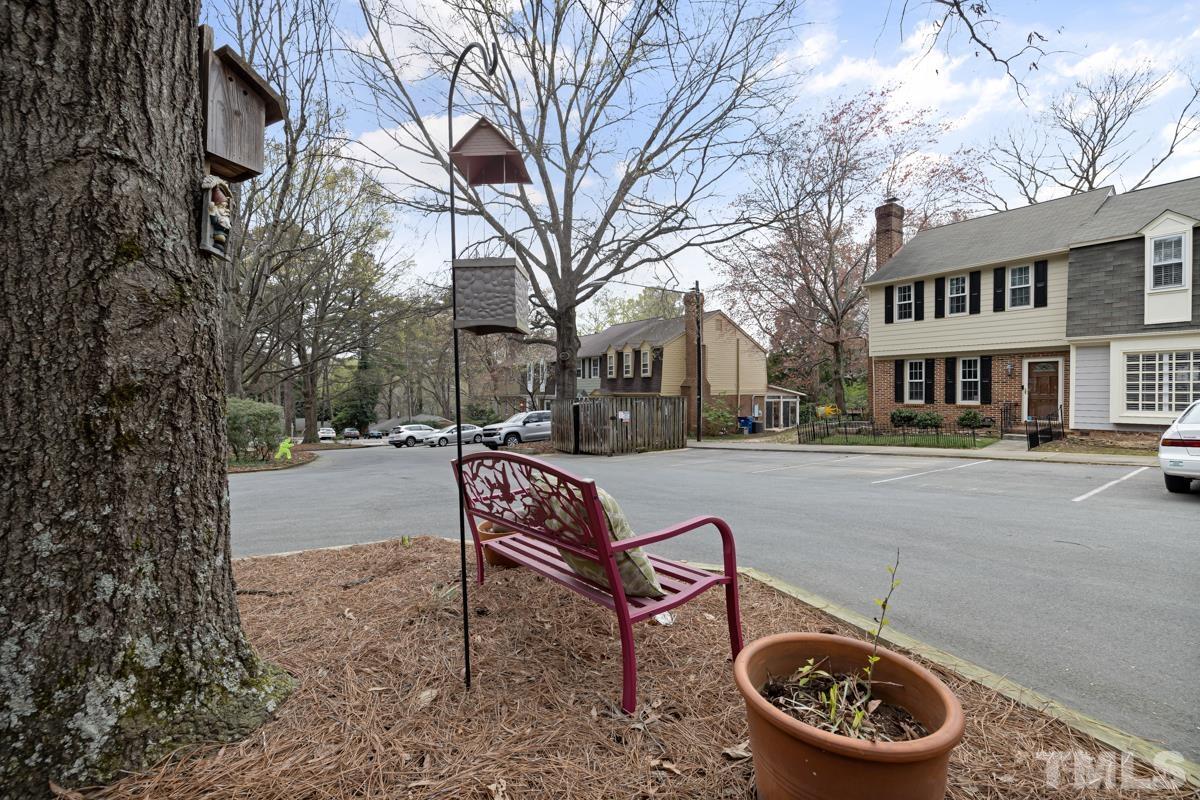 1336 Dylan Heath Court Raleigh, NC 27608 - Photo 24 of 25 a park view with a bench plants and large trees