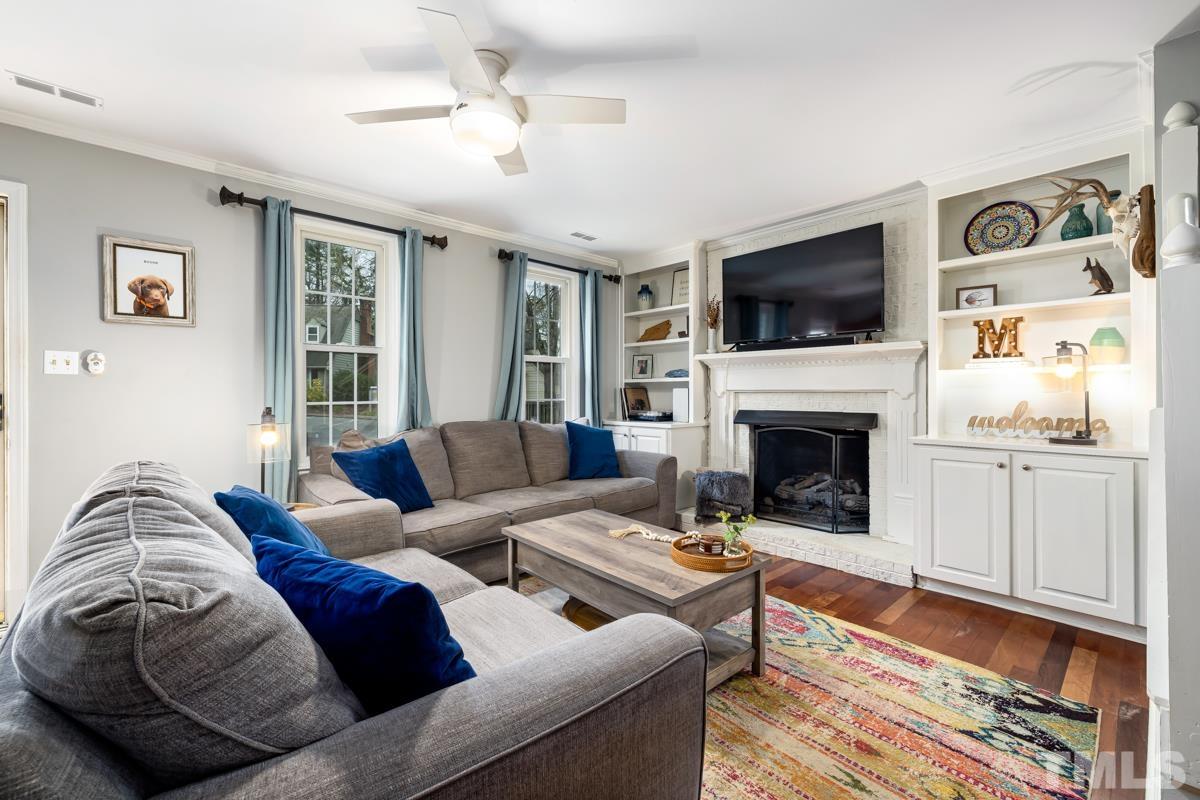 1336 Dylan Heath Court Raleigh, NC 27608 - Photo 3 of 25 a living room with furniture a flat screen tv and a fireplace