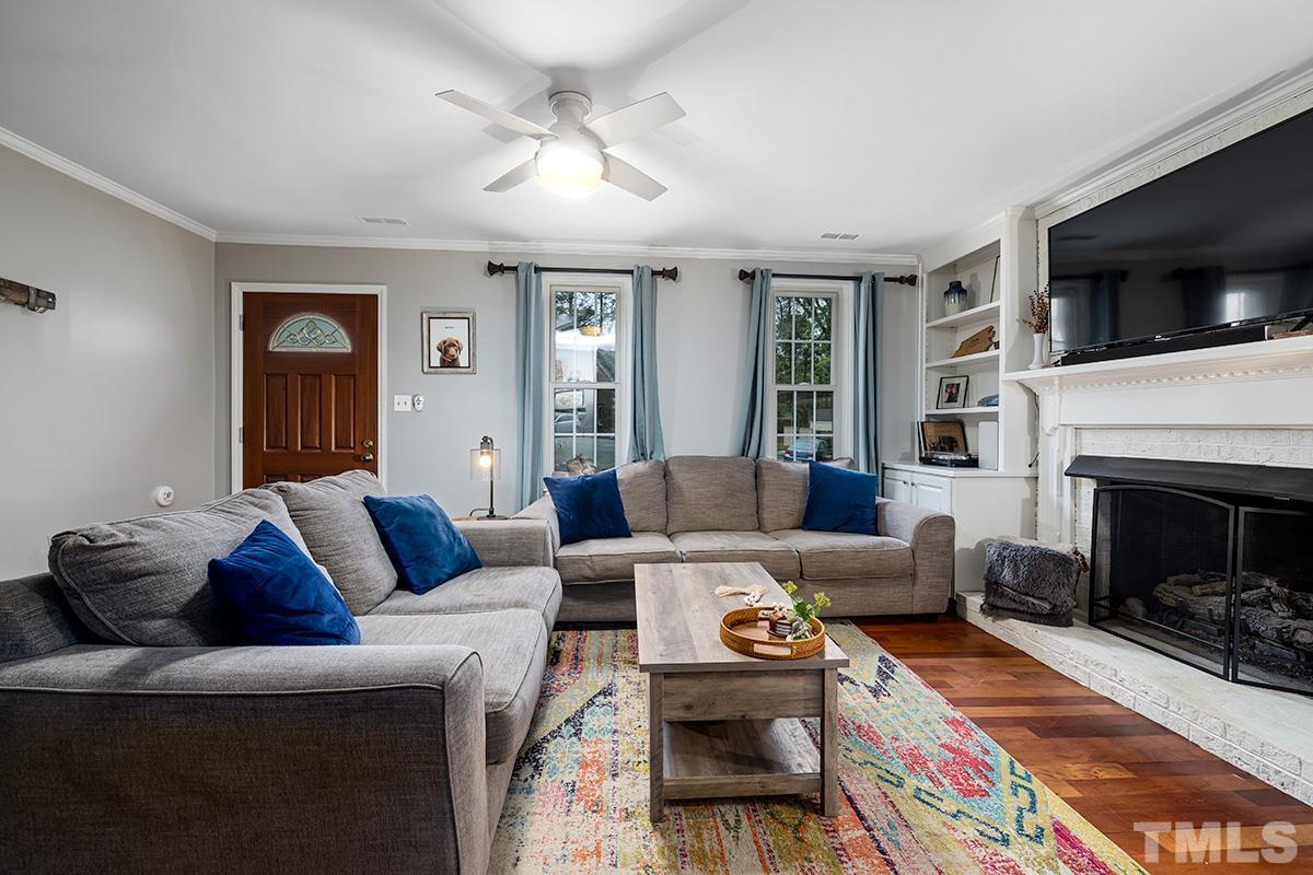1336 Dylan Heath Court Raleigh, NC 27608 - Photo 4 of 25 a living room with furniture a flat screen tv and a fireplace