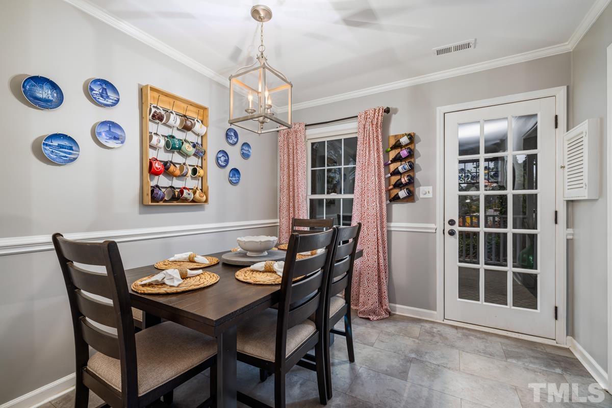 1336 Dylan Heath Court Raleigh, NC 27608 - Photo 7 of 25 a view of a dining room with furniture and chandelier