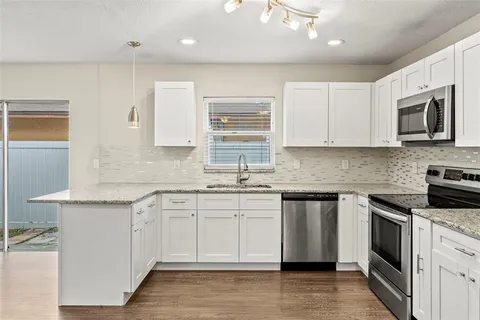 a kitchen with stainless steel appliances granite countertop a stove a sink and a microwave