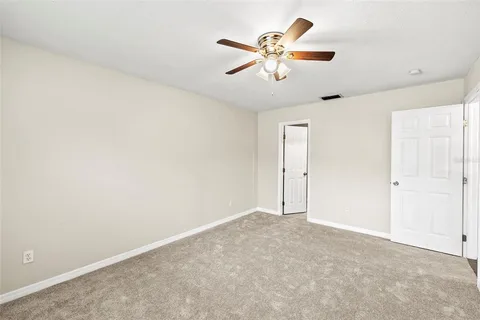 an empty room with chandelier fan