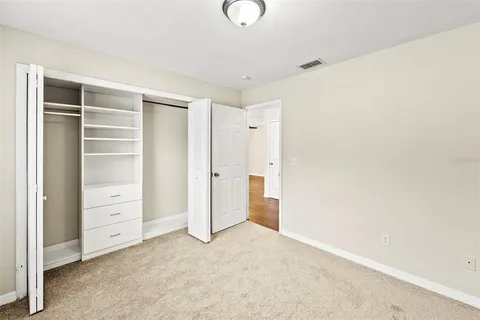 a view of an empty room with closet and cabinet