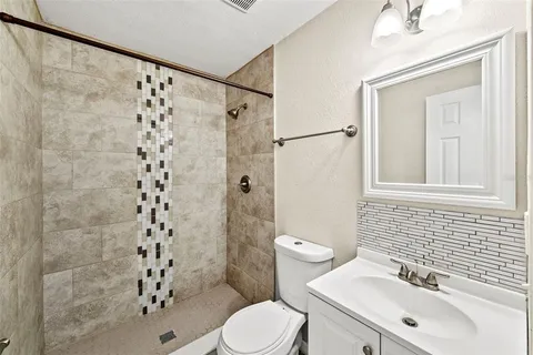 a bathroom with a sink a toilet and shower