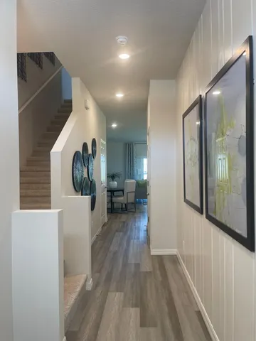 a view of a hallway with wooden floor and dining room