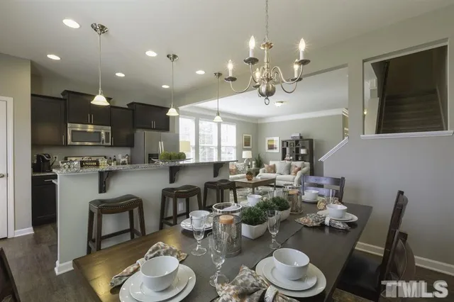 a very nice looking dining room with kitchen island furniture a chandelier and kitchen view
