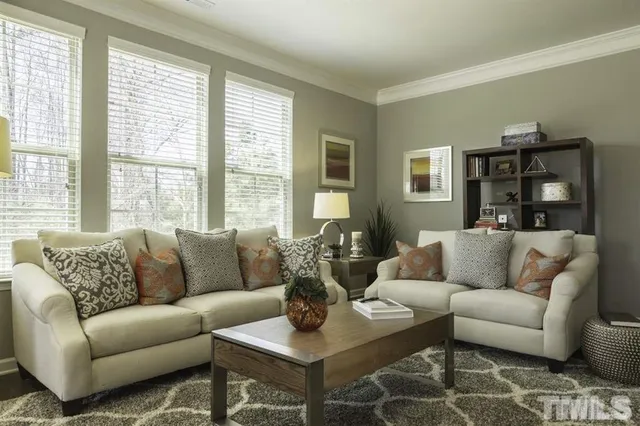 a living room with furniture and large windows