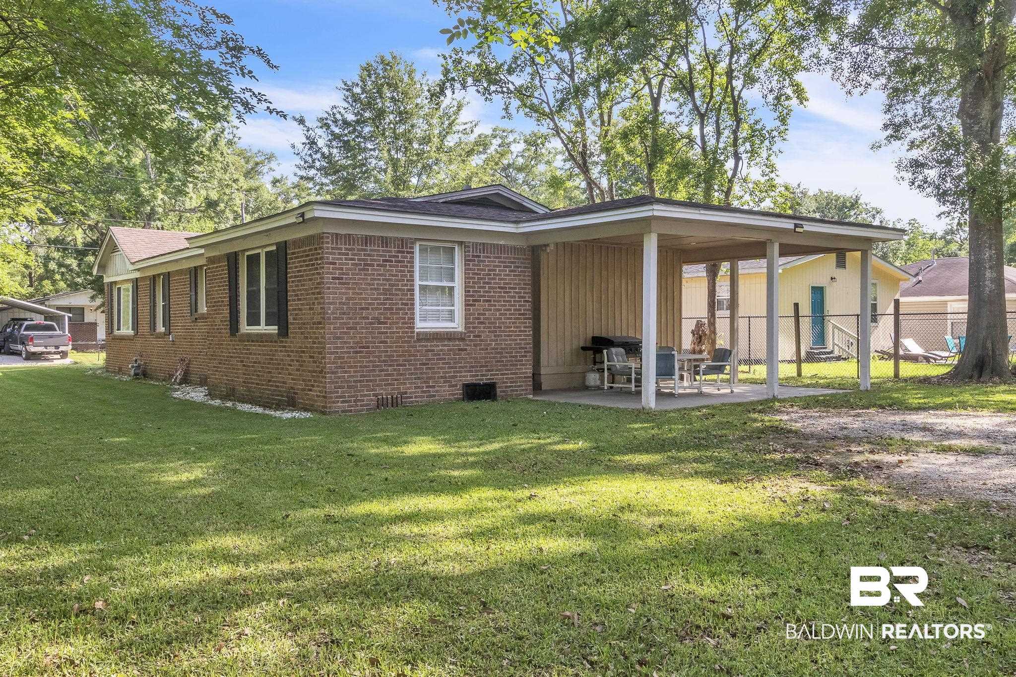 315 Fourth Avenue Chickasaw, AL 36611 - Photo 6 of 28 Rear view of house featuring fence, brick siding, crawl space, a lawn, and a patio