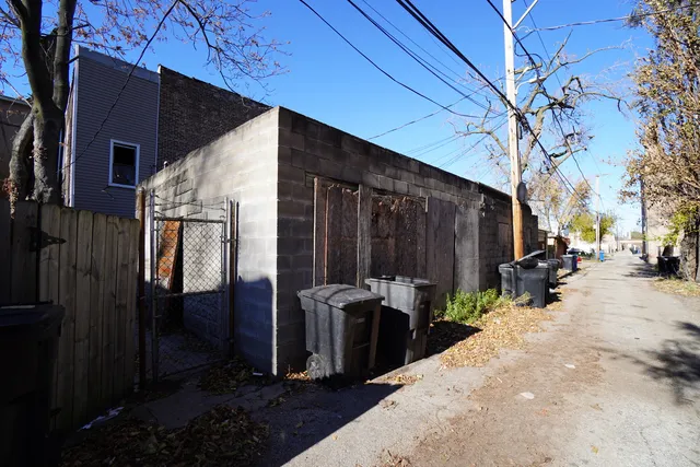 a view of a patio with table and chairs and barbeque grill with wooden fence