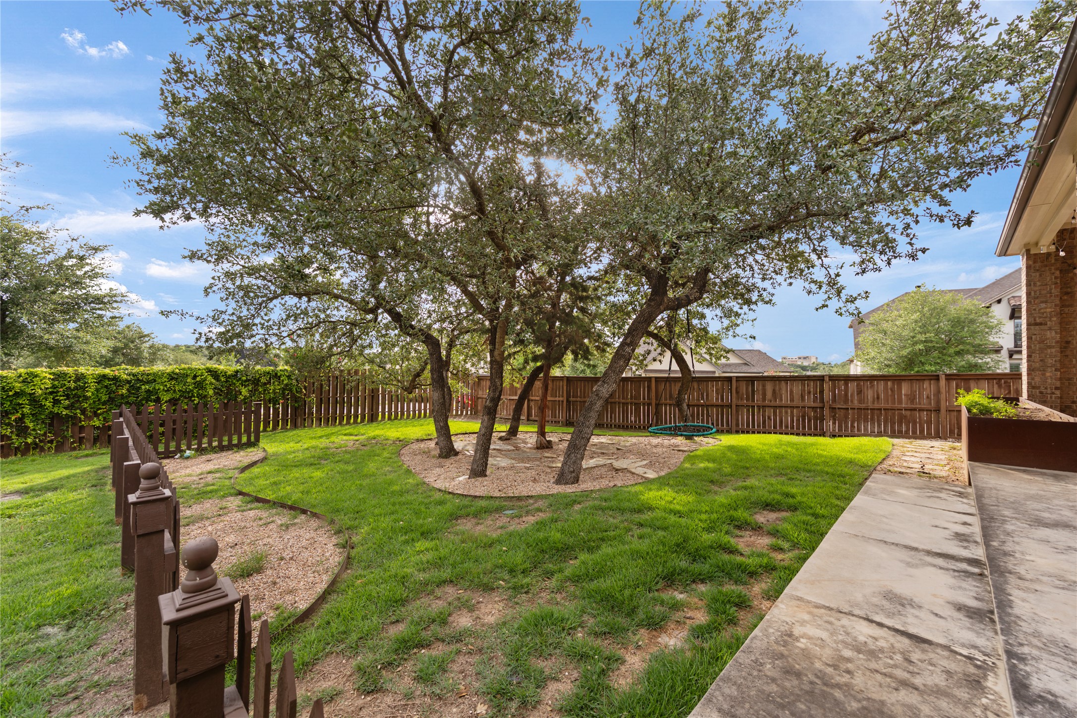 415 Bitterroot Lane Austin, TX 78737 - Photo 22 of 25 A verdant backyard with mature trees and a sturdy privacy fence offers ample space for outdoor enjoyment.