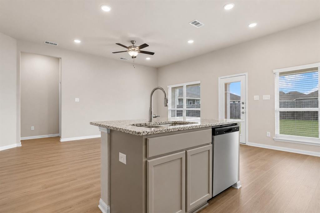 3213 Dottavio Road Lorena, TX 76655 - Photo 11 of 32 a kitchen with granite countertop a stove a sink and a refrigerator with wooden floor