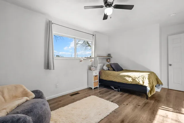 a bedroom with a bed and wooden floor