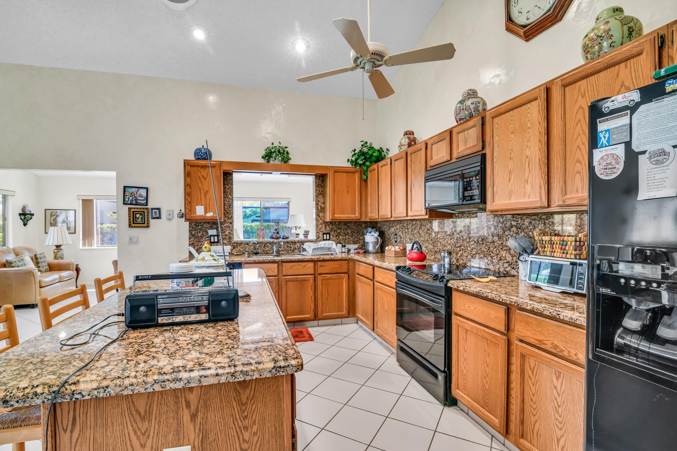 2660 Riviera Drive Delray Beach, FL 33445 - Photo 17 of 40 a kitchen with stainless steel appliances granite countertop sink stove and refrigerator