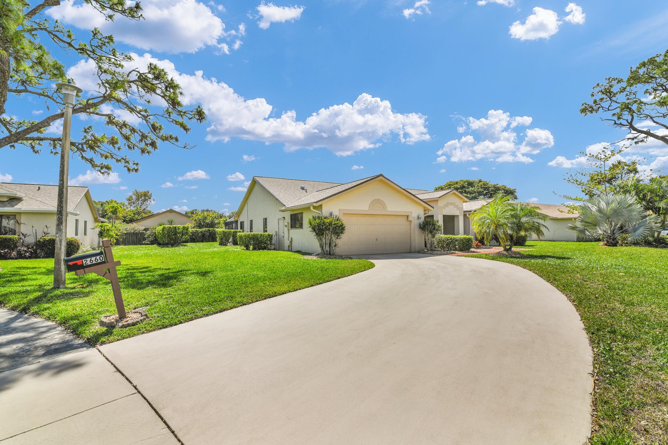 2660 Riviera Drive Delray Beach, FL 33445 - Photo 3 of 40 a front view of a house with garden