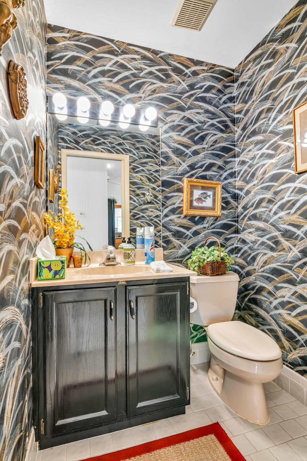 2660 Riviera Drive Delray Beach, FL 33445 - Photo 37 of 40 a bathroom with a toilet a sink and mirror