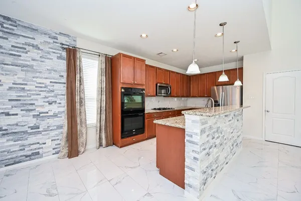 a kitchen with stainless steel appliances granite countertop sink stove and refrigerator