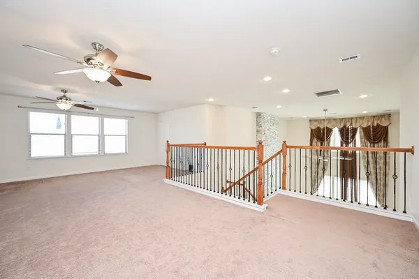 a view of an empty room with a chandelier fan