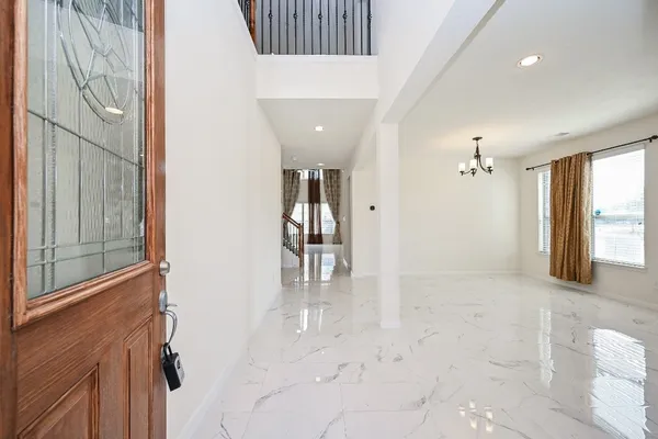 a view of a hallway with wooden floor and staircase
