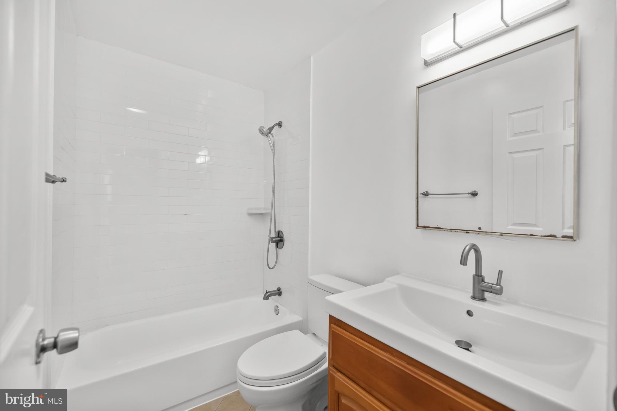 1386 Bryant Street Northeast, Unit 103 Washington, DC 20018 - Photo 18 of 28 a bathroom with a sink a toilet and bathtub