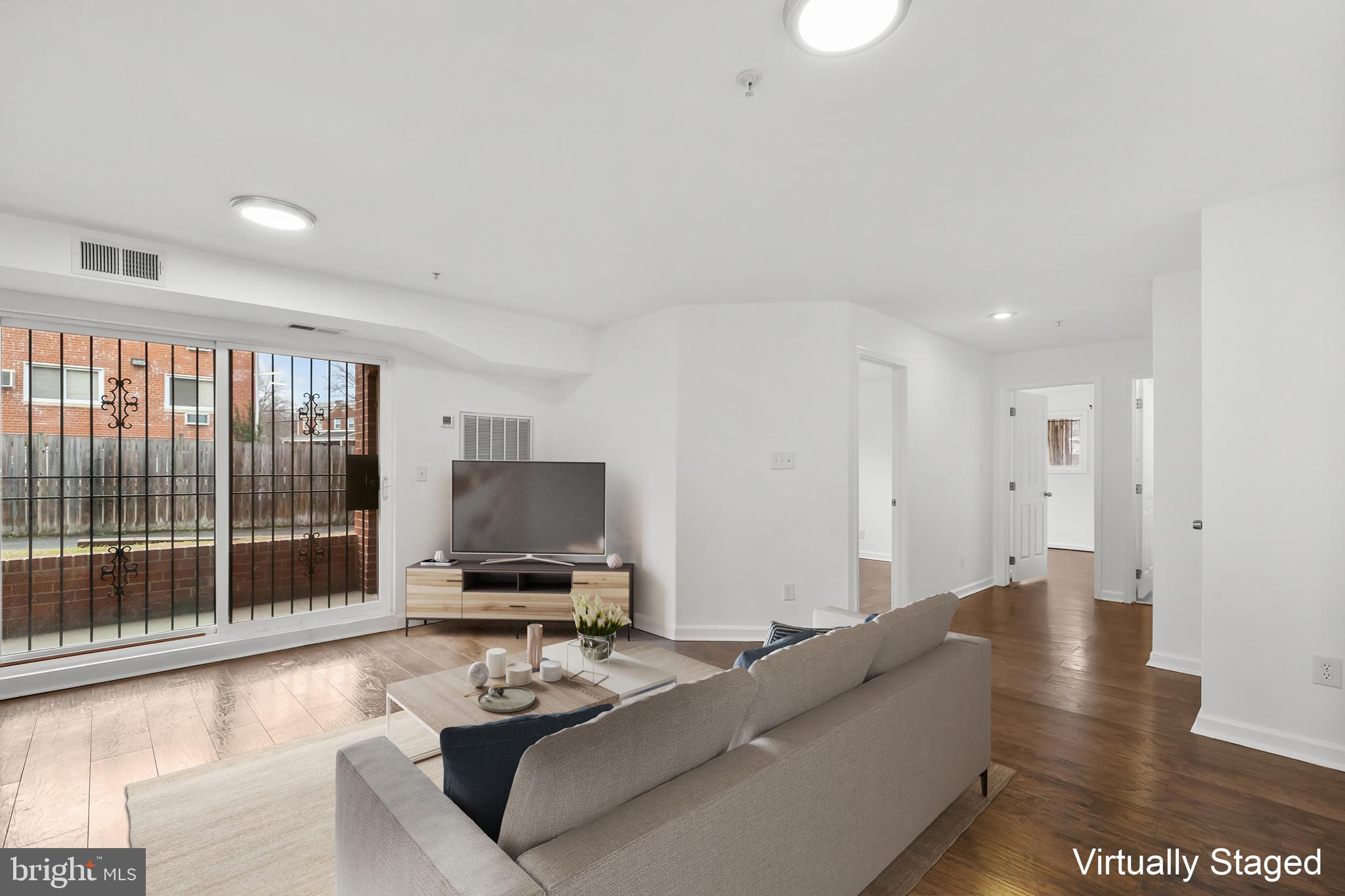 1386 Bryant Street Northeast, Unit 103 Washington, DC 20018 - Photo 3 of 28 a living room with furniture and a flat screen tv