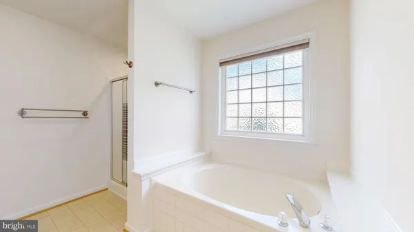 an empty room with chandelier fan and windows